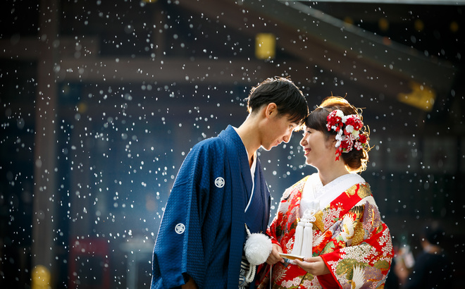 猿田彦神社境内にて　雨が降っている中でおでこをあわす和装の新郎新婦