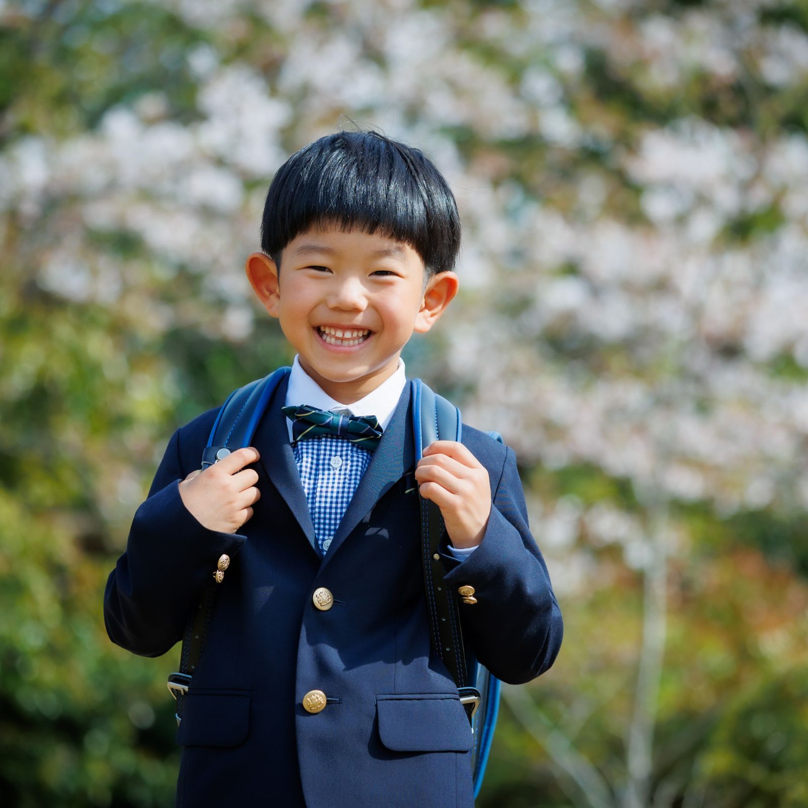 入学記念男の子ランドセルを背負って　桜の木の前で