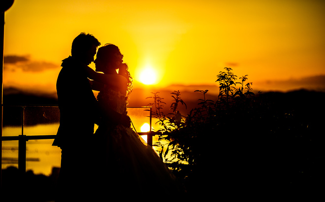 志摩観光ホテルベイスイート屋上にて 英虞湾の夕景をバックに見つめあう新郎新婦