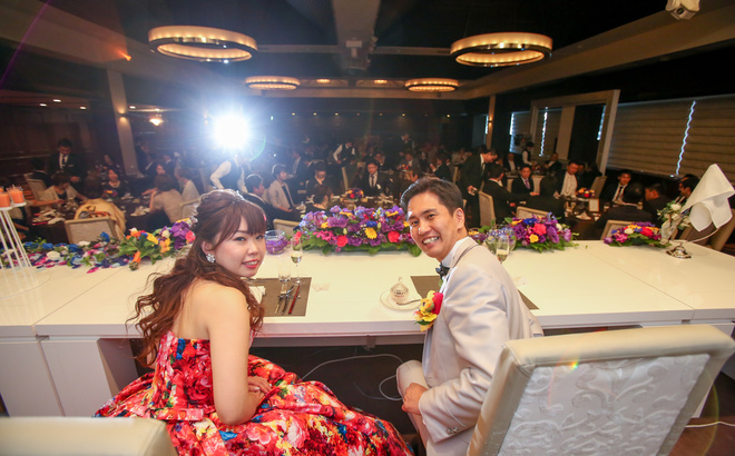 鳥羽国際ホテルバンケット海城での披露宴会場をバックに振り返る新郎新婦