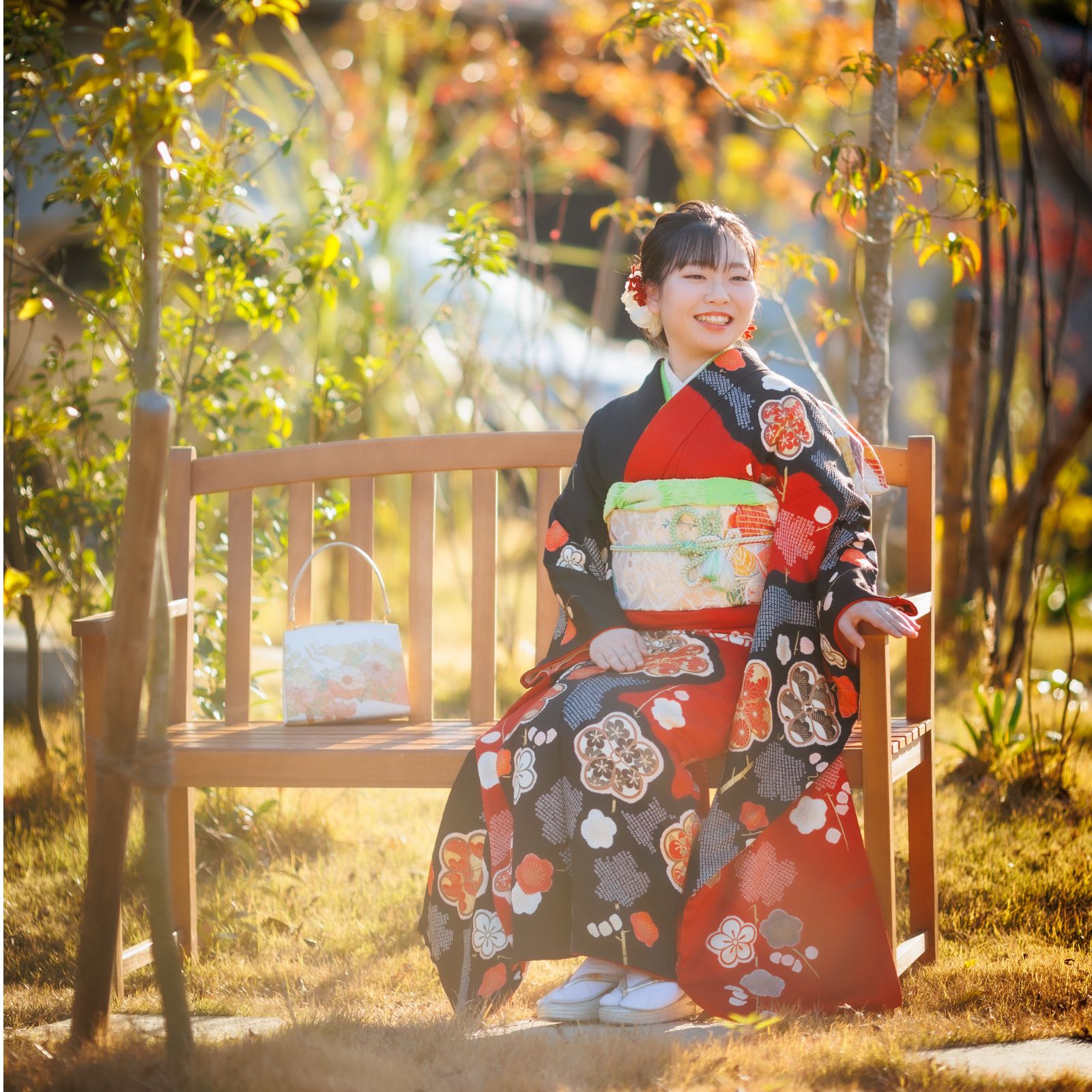 成人式前撮り紅葉バックに椅子に座っている